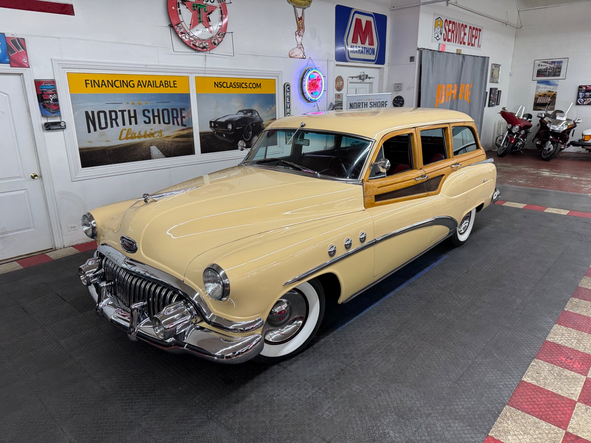 Cream-yellow 1952 Buick Super Estate woodie with whitewall tires, full front three-quarter showroom photograph